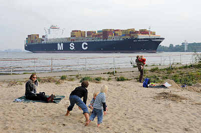 9274 Kinder spielen im Sand an der Elbe - ein Containerfrachter hat den Hamburger Hafen verlassen und fhrt elbabwrts Richtung Nordsee.