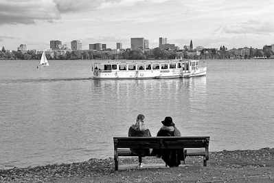 6858 Binnenalster bei Hamburg Rotherbaum - zwei Frauen sitzen auf einer Bank und blicken auf die Binnenalster - ein Alsterschiff fhrt Richtung Binnenalster.