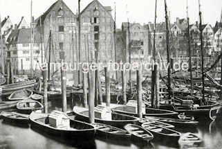 X002154 Alte Fotografie vom Hamburger Binnenhafen bei der Strae Kajen; dicht zusammengedrngt liegen die Boote an den Dalben. Im Hintergrund Lagerhuser und Wohngebude am Hafenrand.